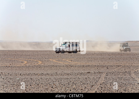 Long shot of four wheel drive vehicles approaching camera kicking up dust trails in Egypt's Eastern desert Stock Photo