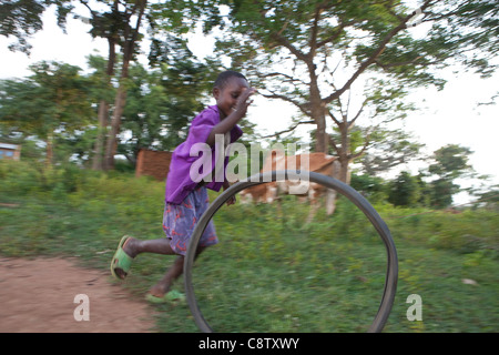 A child plays with a bicycle tire in Pallisa District, in Eastern Uganda. ActionAid - Uganda. October, 2011. Stock Photo