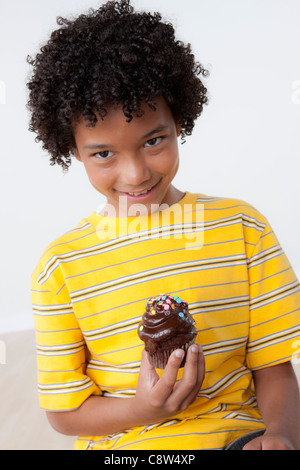 Studio portrait of boy holding muffin Stock Photo