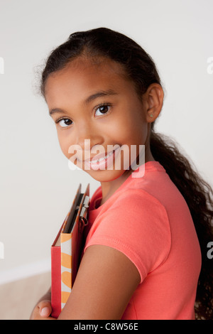 Studio portrait of girl holding books Stock Photo