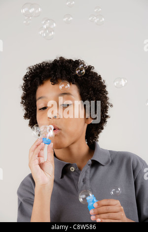 Studio portrait of boy blowing bubbles Stock Photo
