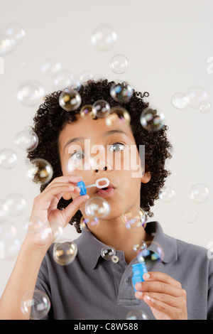 Studio portrait of boy blowing bubbles Stock Photo