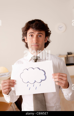 Studio portrait of businessman holding sheet of paper with cloud drawing Stock Photo
