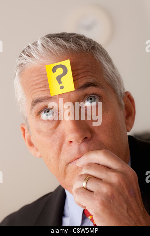 Studio portrait of senior businessman with adhesive note on forehead Stock Photo