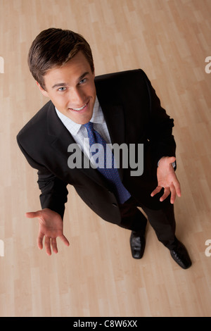 Portrait of young smiling businessman gesturing Stock Photo
