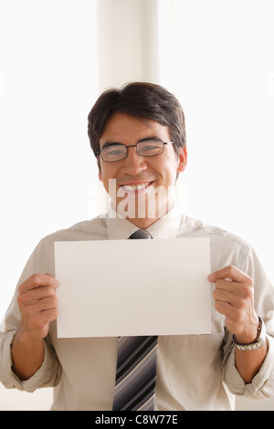 Studio shot of business man holding blank paper Stock Photo