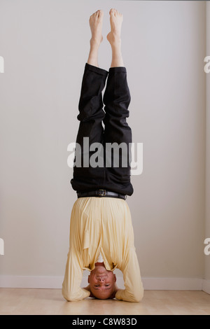 Mature businessman doing headstand Stock Photo