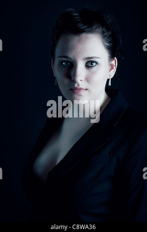 Low-key portrait of young woman wearing a suit jacket Stock Photo