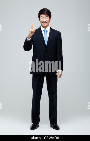 Portrait Of Businessman Pointing Upward Stock Photo