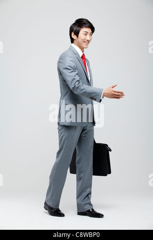 Asian Businessman Extending A Hand To Shake Stock Photo