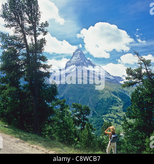 Woman looking at the Matterhorn through binoculars Zermatt Valais Switzerland Europe Stock Photo