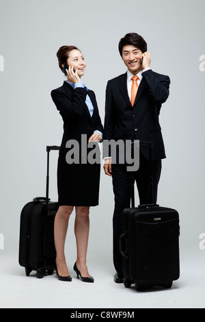 Asian Businesswoman And Businessman Using Cell Phone Stock Photo