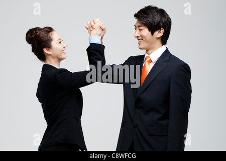 Asian Businessman And Businesswoman Joining Hands Stock Photo