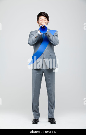 Portrait Of Asian Businessman Holding Megaphone, Wearing Sash Stock Photo