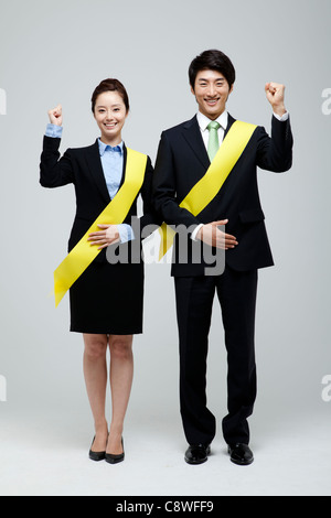 Portrait Of Asian Businessman And Businesswoman Cheering And Wearing Sash Stock Photo