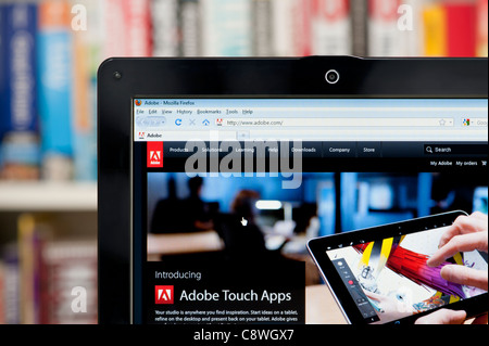The Adobe website shot against a bookcase background (Editorial use only: ­print, TV, e-book and editorial website). Stock Photo