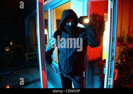 Burglar in a private house. Nighttime burglary. Breaking into a house to steel valuables. Stock Photo