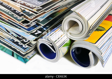 Pile of various multicolored stack and rolled up magazines on white background Stock Photo