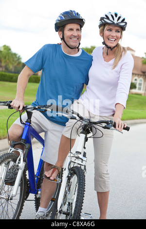 A young happy man and woman couple riding their bicycles or bikes Stock Photo