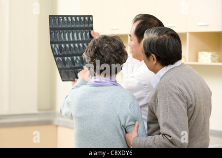 Doctor Shows an X-Ray Test Results to Senior Couple Stock Photo