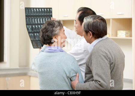 Doctor Shows an X-Ray Test Results to Senior Couple Stock Photo