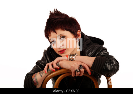 young woman with tattoos piercings and short cropped dark hair Stock Photo