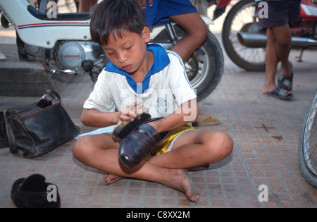 Child labourers work in a Phnom Penh Cambodia. Shoe shine boy. Stock Photo
