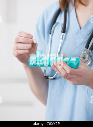 USA, Illinois, Metamora, Female doctor putting pill into pill container Stock Photo