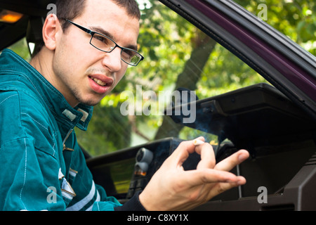 Young worker smoking in the car. Stock Photo