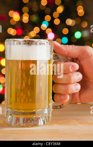 USA, Illinois, Metamora, Man's hand holding beer, Christmas lights in background
