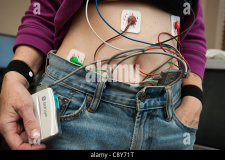 A woman wears a Holter, an ambulatory electrocardiography device, monitors the electrical activity of her cardiovascular system Stock Photo