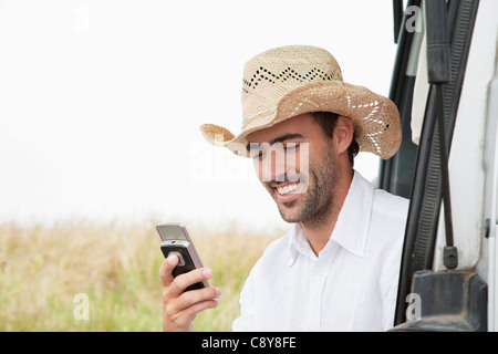 portrait of young man wearing straw hat with mobile phone Stock Photo