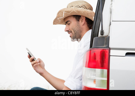 portrait of young man wearing straw hat with mobile phone Stock Photo