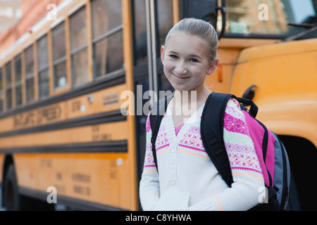 USA, New York State, New York City, Portrait of smiling girl (10-11), school bus in background Stock Photo
