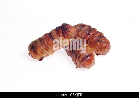 Hot, cooked Piggies in blankets, also known as pigs in a blanket, sausages wrapped in bacon on white background cutout. Stock Photo