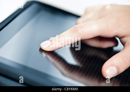 Female hand touching tablet computer screen with finger Stock Photo