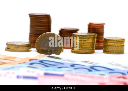 Euro coins with euro banknotes in the foreground isolated on white Stock Photo