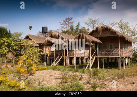 India, Assam, Majuli Island, tourism, bamboo eco cottage tourist accommodation at edge of paddy fields Stock Photo