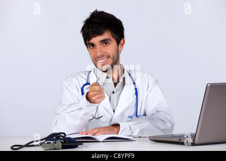 happy young doctor working at his desk (isolated on gray) Stock Photo