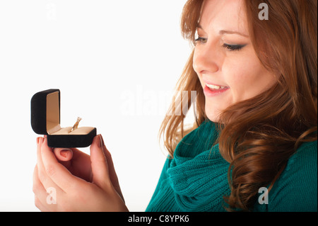 Young woman looking at diamond ring in jewelry gift box Stock Photo