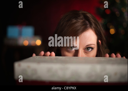 Woman behind gift box at Christmas time Stock Photo