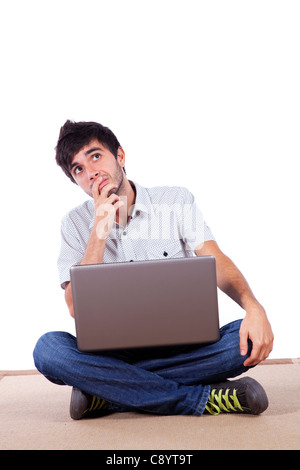 Young man working with his laptop on the home floor (isolated on white) Stock Photo