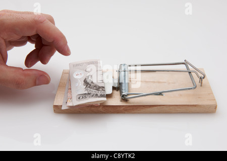 Male hand taking fifty pound note from mousetrap