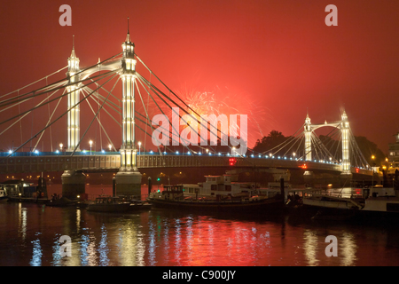Fireworks explode during Battersea Park Fireworks Display celebrating Guy Fawkes Night in London, UK, on 05 November 2011 with the Albert Bridge and river Thames in foreground. Stock Photo