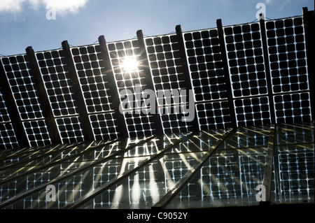 The sun bursts through the inside of Solar Panals installed on the roof of a building at The Centre for Alternative Technology, or CAT, Europe's leading Eco-centre, in Powys, Wales. Stock Photo