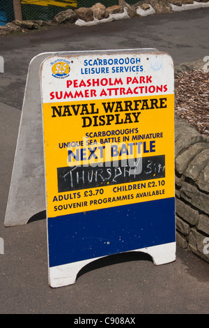 Advertising board for Naval Warfare Display, using model boats, on lake in Peasholm Park, Scarborough Stock Photo