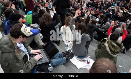 Occupy London activists & man with laptop & anonymous mask sit on steps of St. Paul's Cathedral October 2011 KATHY DEWITT Stock Photo