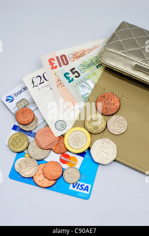 money and credit cards spilling out of a purse Stock Photo
