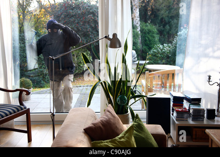 Burglar in a private house. Daylight burglary. Breaking into a house, an apartment to steel valuables. Stock Photo