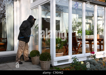 Burglar in a private house. Daylight burglary. Breaking into a house, an apartment to steel valuables. Stock Photo